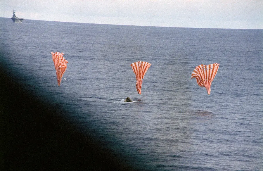 Apollo 13's command module splashes down in the South Pacific under its three parachutes, 17 April 1970.
