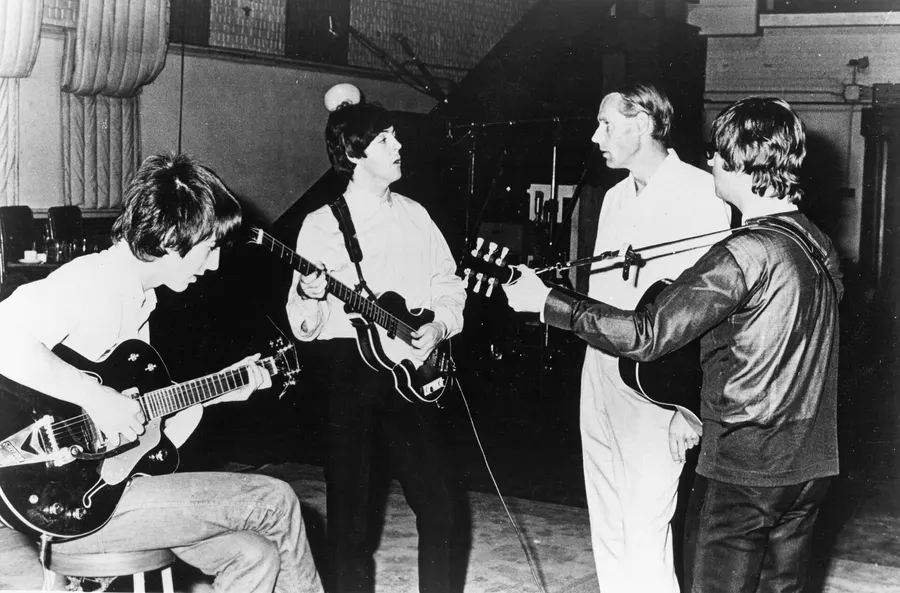 John Lennon, George Harrison and Paul McCartney with their producer George Martin at Abbey Road, 1966.