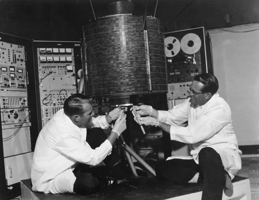 Engineers check the Early Bird satellite before its launch in 1965.