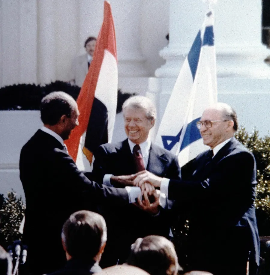 Anwar Sadat, Jimmy Carter and Menachem Begin shake hands at the signing on the White House lawn, 26 March 1979.