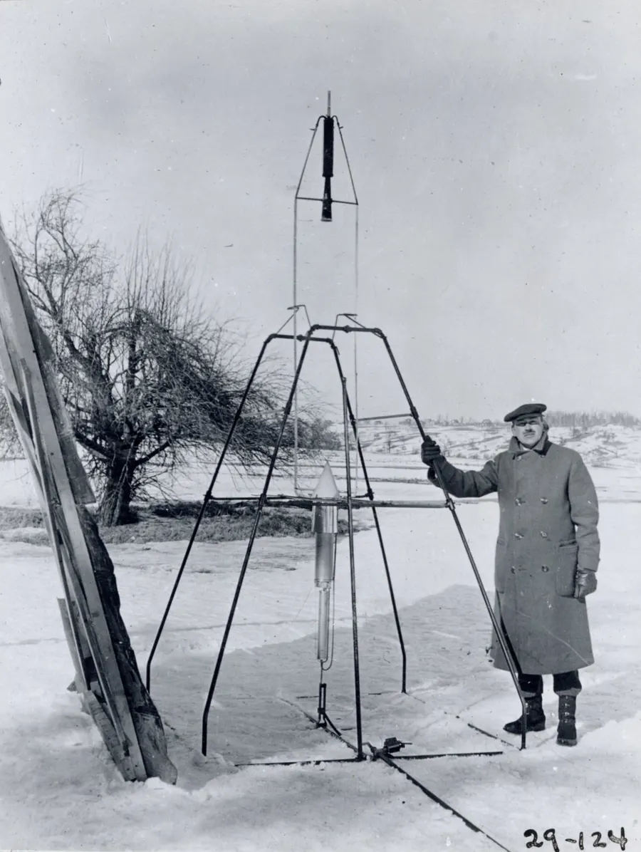 Robert Goddard beside his rocket and its launch frame at Auburn, Massachusetts, on 16 March 1926.