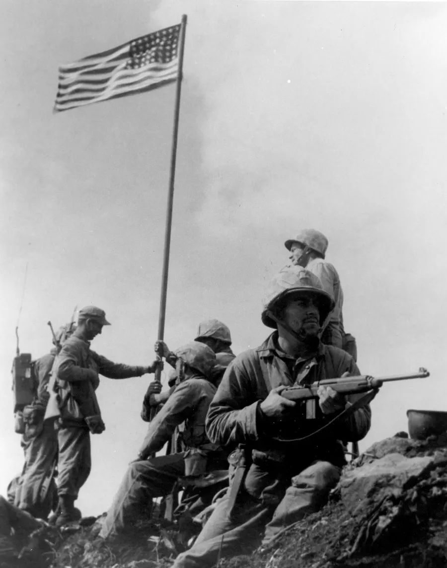 The first flag raised on Mount Suribachi, at 10.20 on 23 February 1945, photographed by Staff Sergeant Louis Lowery.