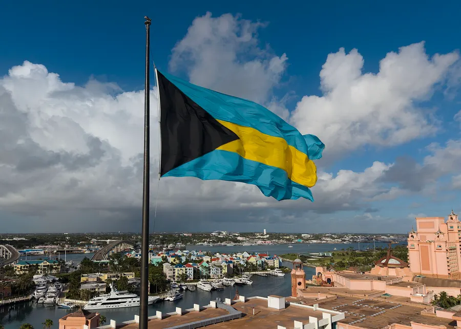 The flag of the Bahamas, black, aquamarine and gold, flying over Nassau