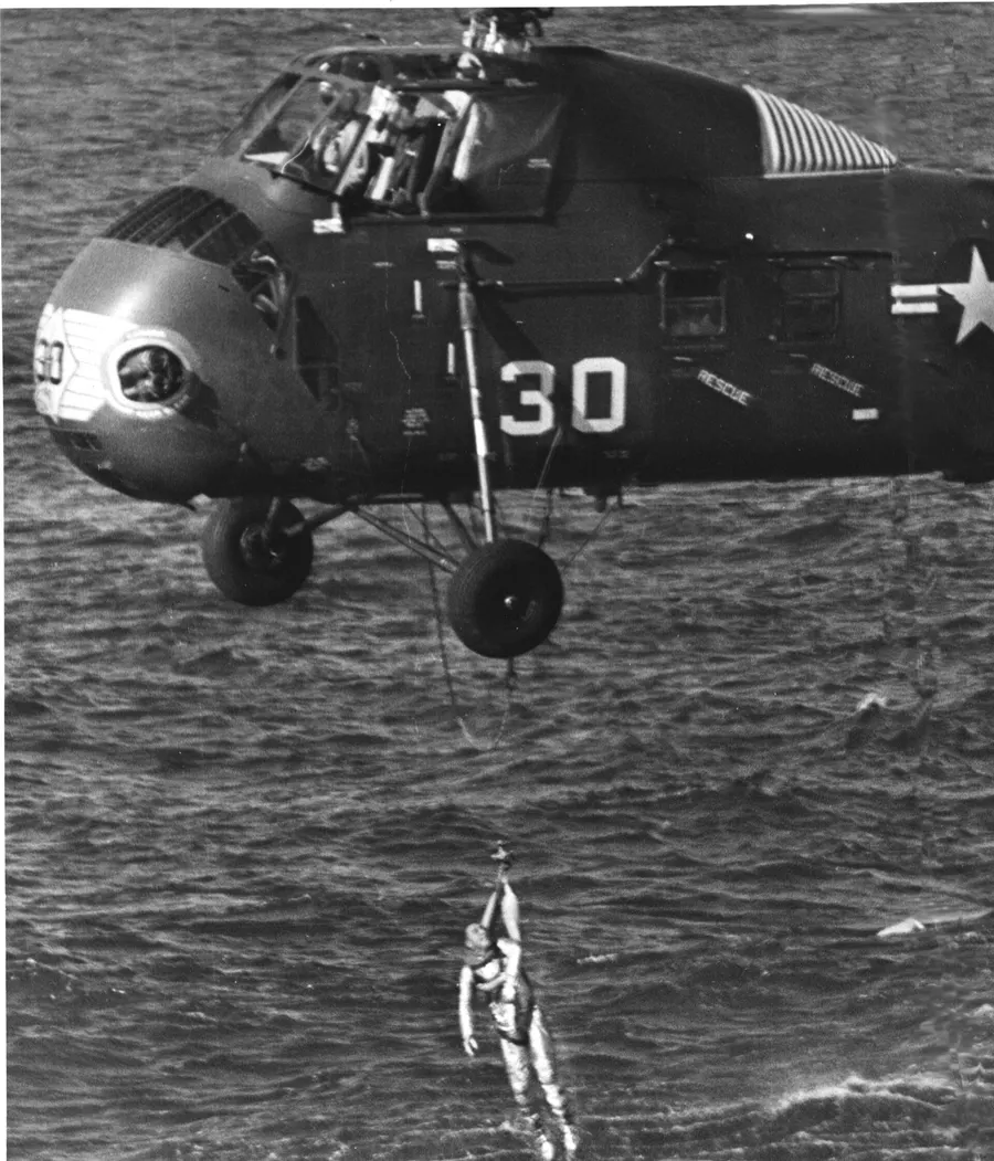 Gus Grissom is lifted from the sea by a recovery helicopter after the flight of Liberty Bell 7