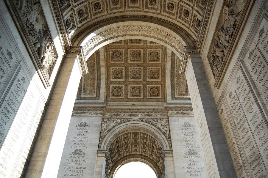 Looking up into the Arc de Triomphe in Paris, with the names of battles and generals carved on its inner walls