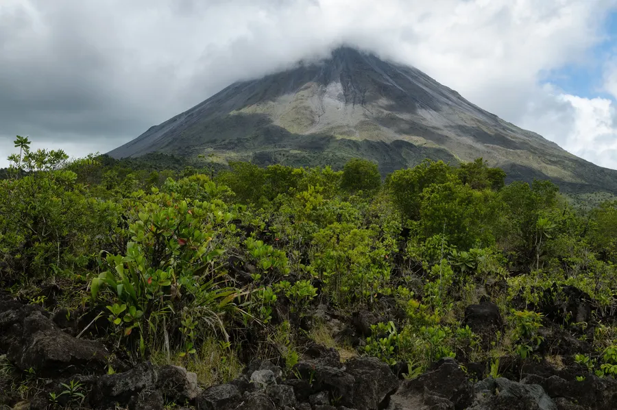 Arenal volcano in Costa Rica, seen across rough ground and forest on the flow of lava it poured out after 1968