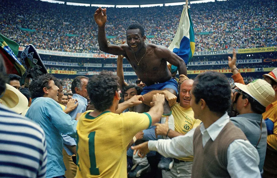 Pelé carried shoulder-high at the Estadio Azteca after Brazil's World Cup final win over Italy on 21 June 1970, an Associated Press photograph