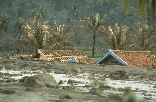 Houses half-buried by a lahar, a flow of volcanic debris and water, from Galunggung volcano on Java during its 1982 eruption (US Geological Survey photograph)