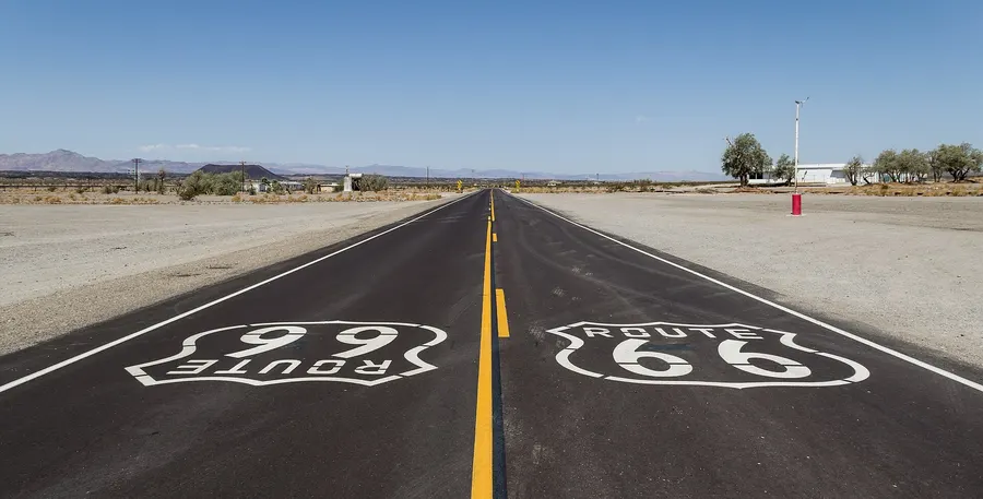 The old Route 66 near Amboy in the Mojave Desert, California, with the highway's shield painted on the road