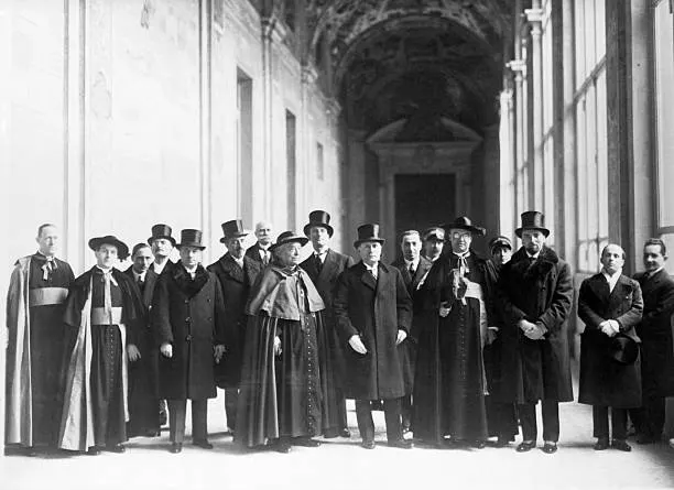 Cardinal Pietro Gasparri and Benito Mussolini (centre) with Vatican and Italian officials at the Lateran Palace before the signing, February 1929.