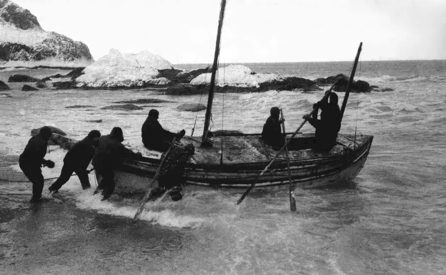 The James Caird being launched from the beach at Elephant Island, probably photographed by Frank Hurley.