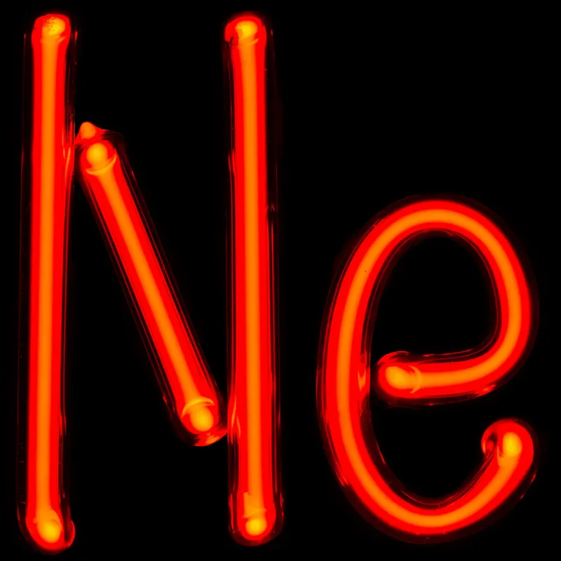 A neon-filled glass tube bent into the element's symbol, Ne, glowing its characteristic red-orange.