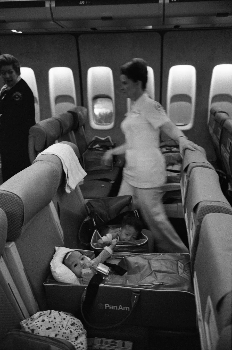 Nurses care for Vietnamese children on an Operation Babylift flight arriving at San Francisco, 5 April 1975.