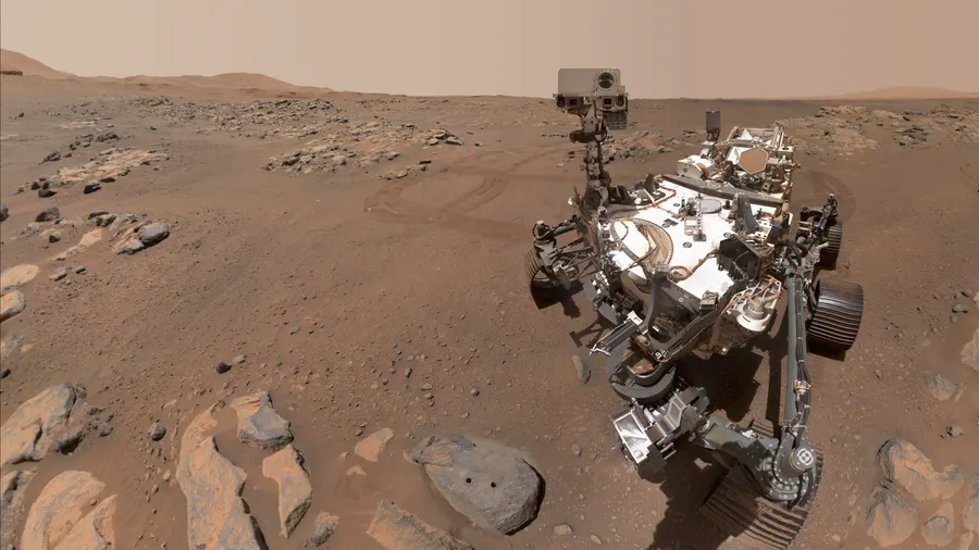 Perseverance photographs itself beside a rock nicknamed 'Rochette', with two holes it drilled for samples, on Mars in September 2021.