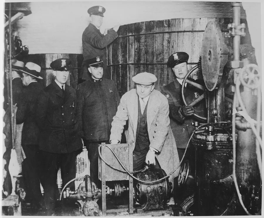 Detroit police inspect equipment from a hidden underground brewery during the Prohibition era.