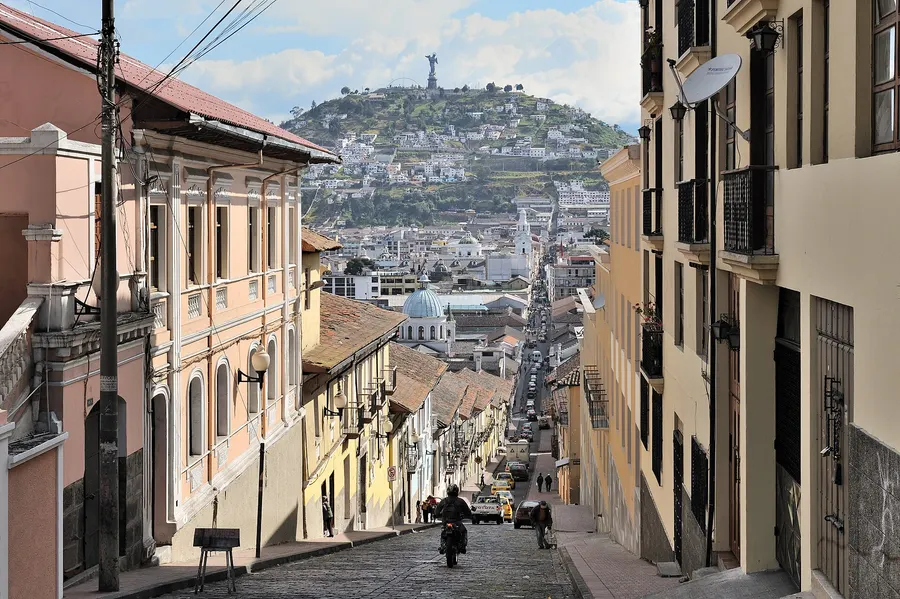 García Moreno street in Quito's historic centre, with the statue of the Virgin of Quito on the hill behind.