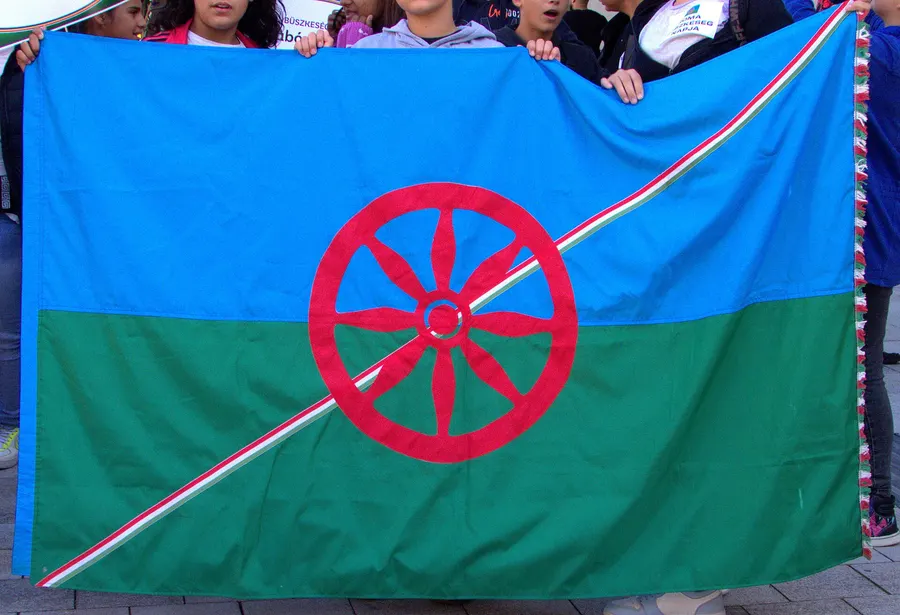 Children holding the Romani flag at a Roma Pride event, 2025.