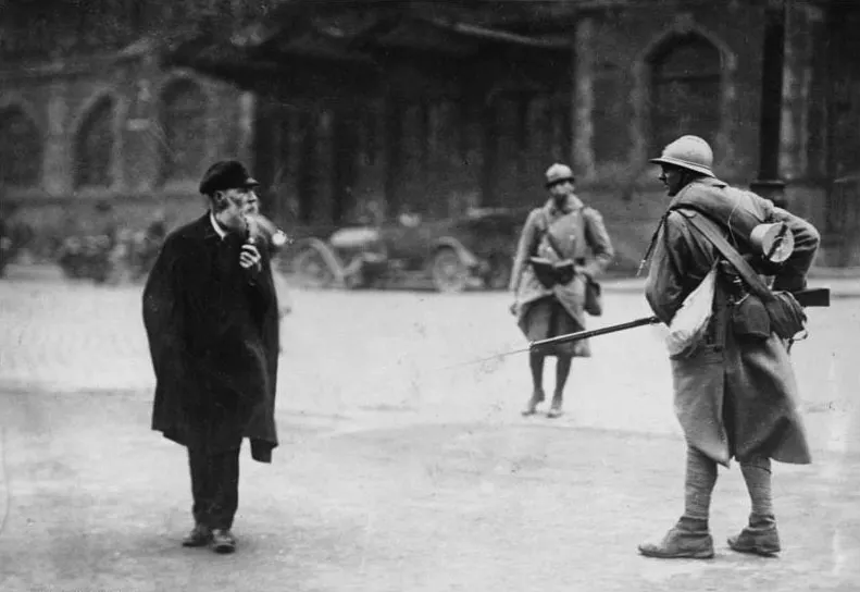 French soldiers on a street in the occupied Ruhr in 1923; a German civilian walks past.