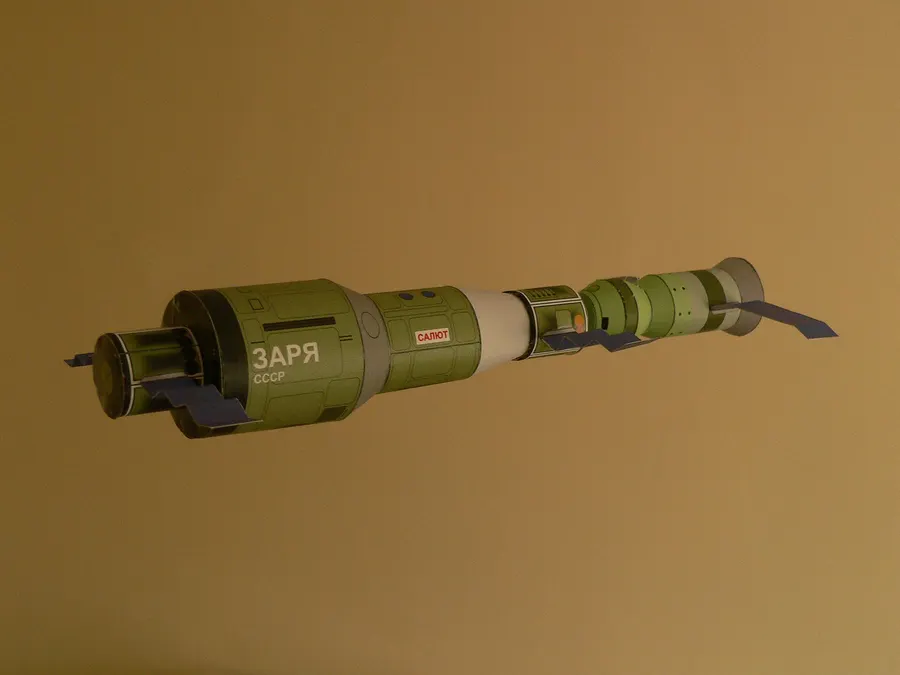 A paper model of Salyut 1 with a Soyuz spacecraft docked at one end.