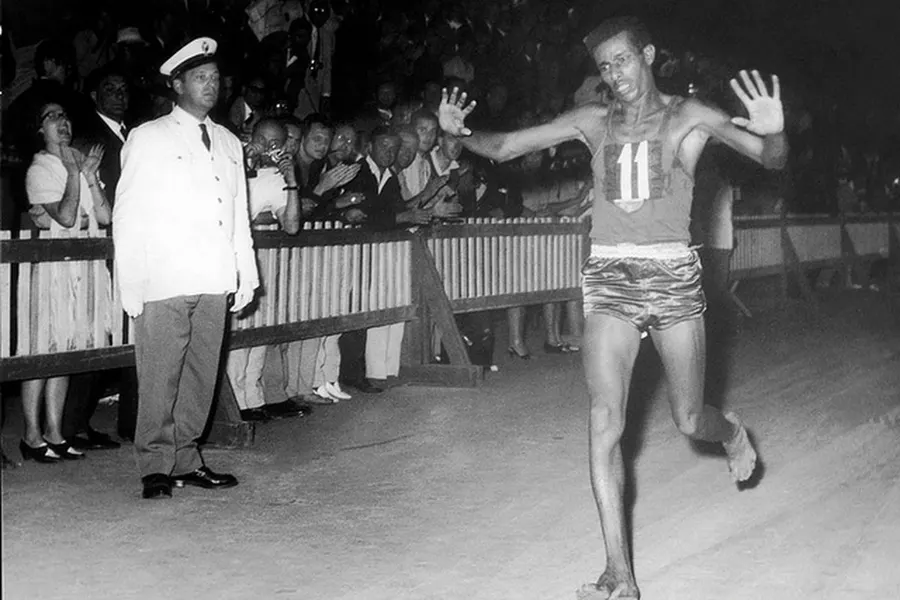 Abebe Bikila, barefoot, raises his arms as he finishes the Olympic marathon in Rome on the evening of 10 September 1960