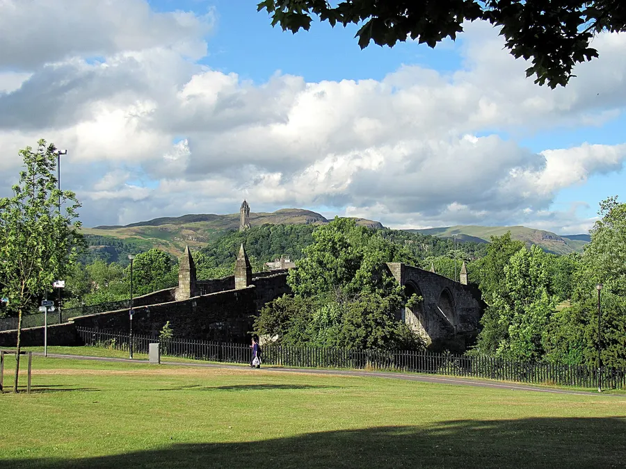 The old stone bridge over the River Forth at Stirling, with the Wallace Monument on the hill behind; the wooden bridge of 1297 stood close to this spot