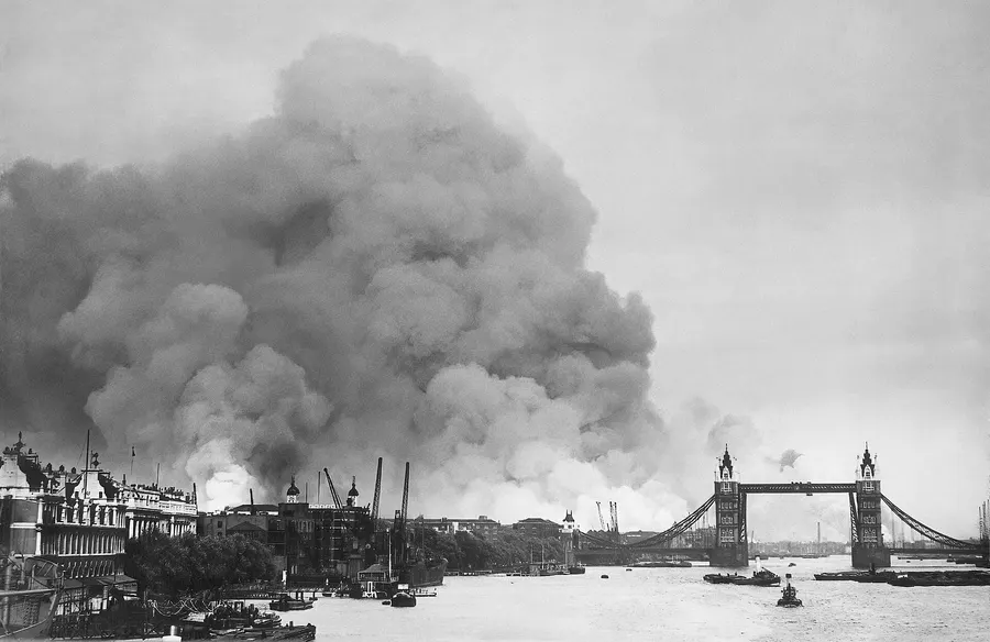 Smoke rises over the London docks after an air raid during the Blitz, seen along the River Thames