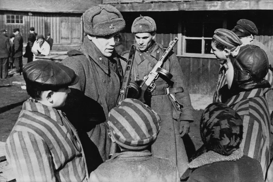 Soviet soldiers with children just freed from Auschwitz, January 1945.