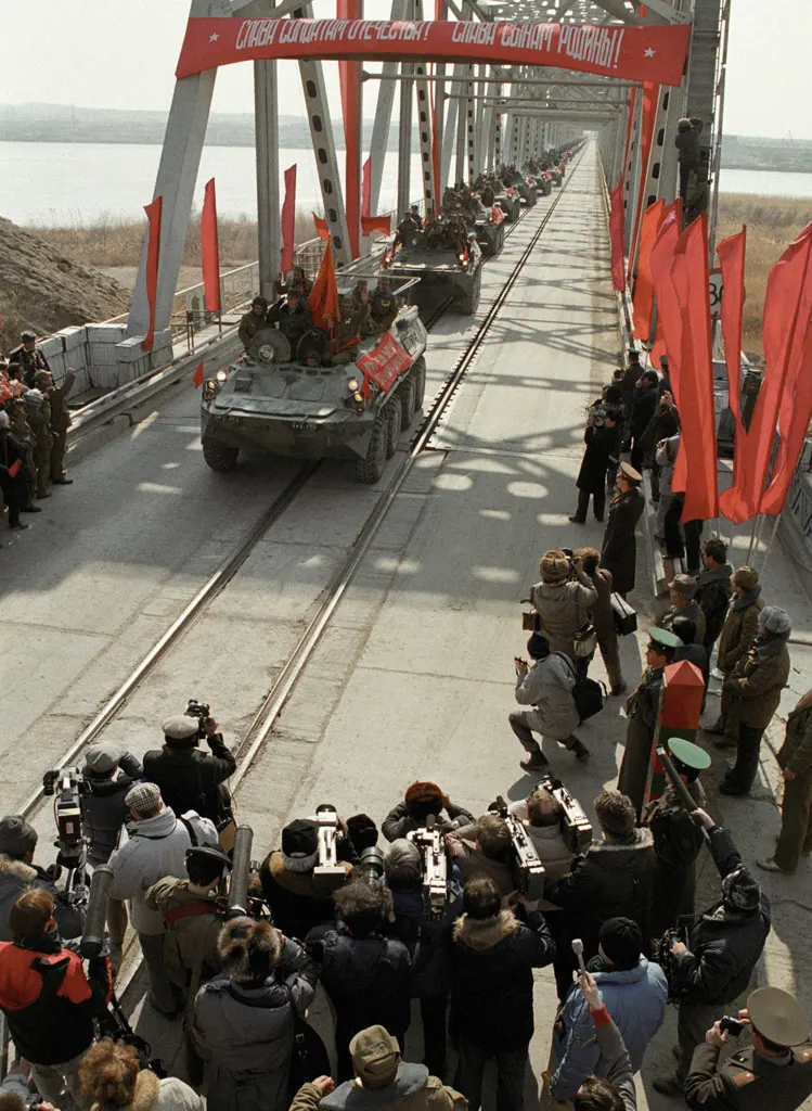 The last Soviet column crosses the bridge into the Soviet Union on 15 February 1989, under a banner reading 'Glory to the soldiers of the fatherland!'