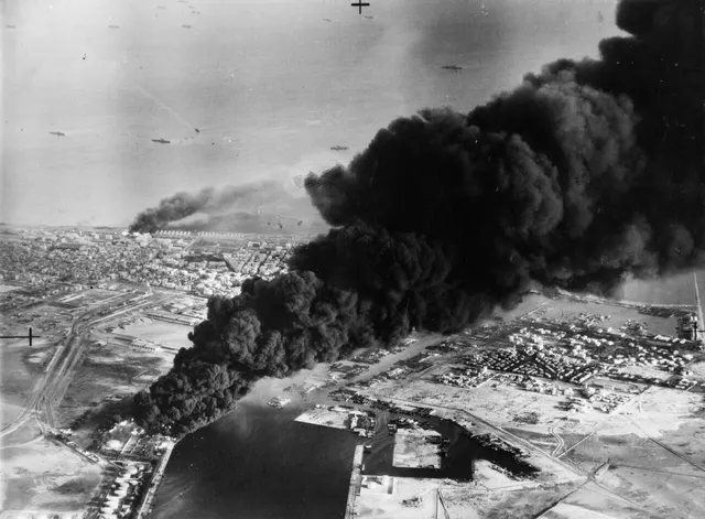Smoke rises from oil tanks at Port Said during the Anglo-French landings of 5 November 1956.
