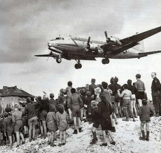 Berlin children watch an American supply plane come in to land, 1948.