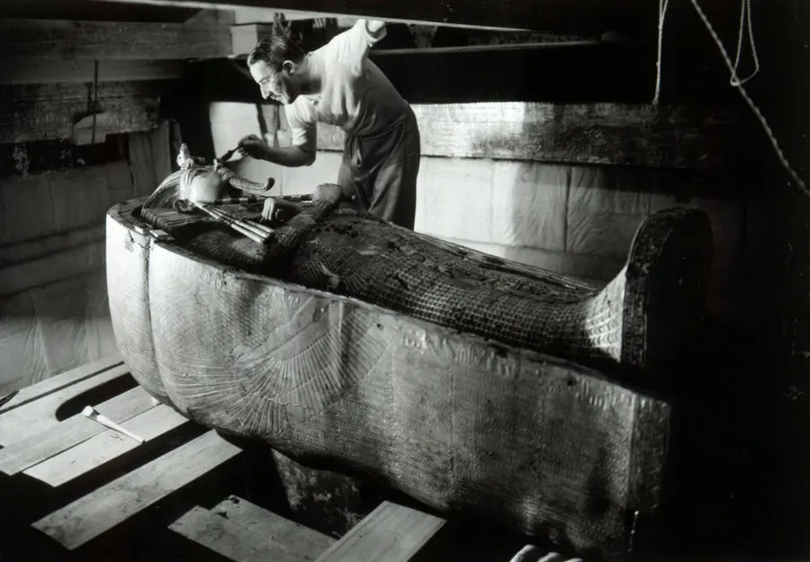 Howard Carter at work on the stone sarcophagus in the burial chamber of Tutankhamun's tomb.