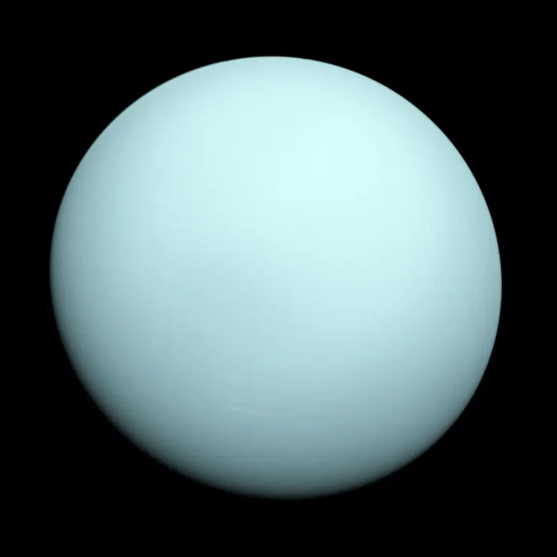 Uranus photographed by Voyager 2 in January 1986, a nearly featureless blue-green globe.
